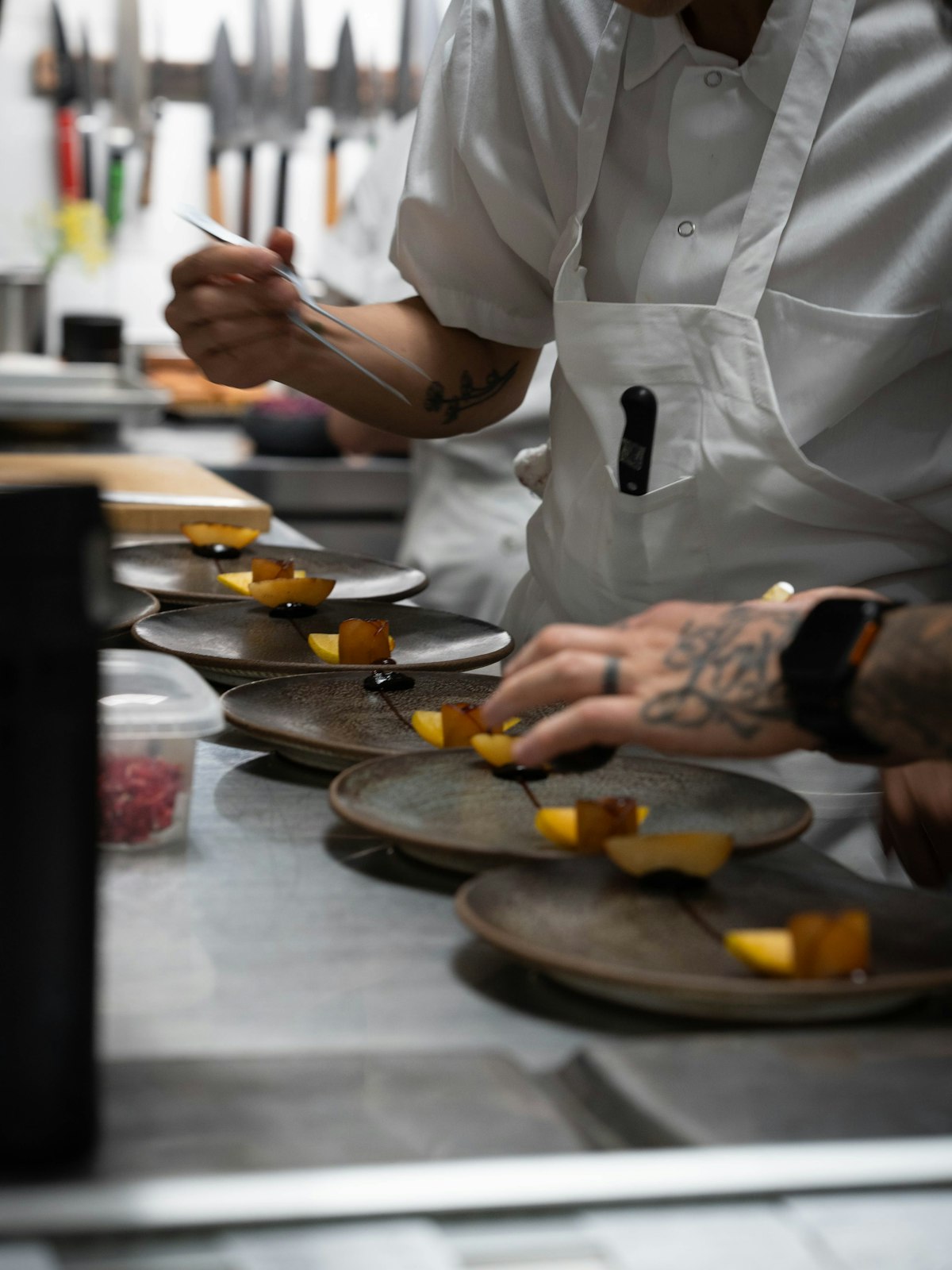 Private chef plating a refined dish, hands only, aboard a luxury yacht setting.